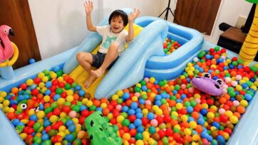 Kid Plays in Giant Ball Pit with Inflatable Slide - Fun Indoor Playtime Adventure